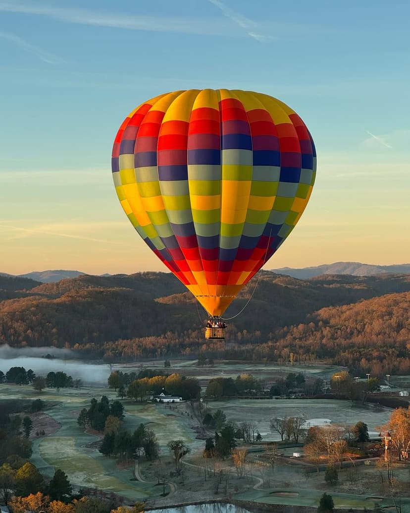 Colorful balloon flying over Blue Ridge Mountains with morning mist