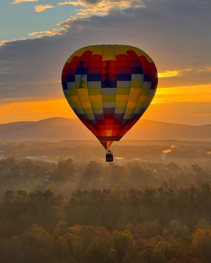 Hot air balloon silhouetted against golden sunset over Virginia